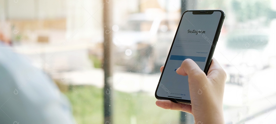 Uma mulher segura o Apple iPhone X com o aplicativo Instagram na tela