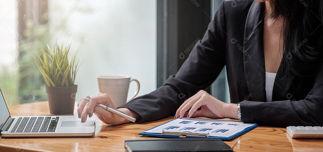 Uma mulher de negócios analisando gráficos de investimento no local de trabalho