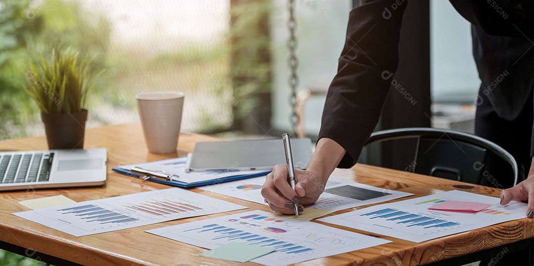 Análise de homem de negócios com papel de dados usando calculadora no escritório