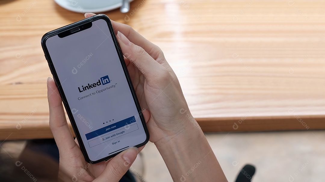 Uma mulher segura o Apple iPhone Xs com o aplicativo LinkedIn na tela.