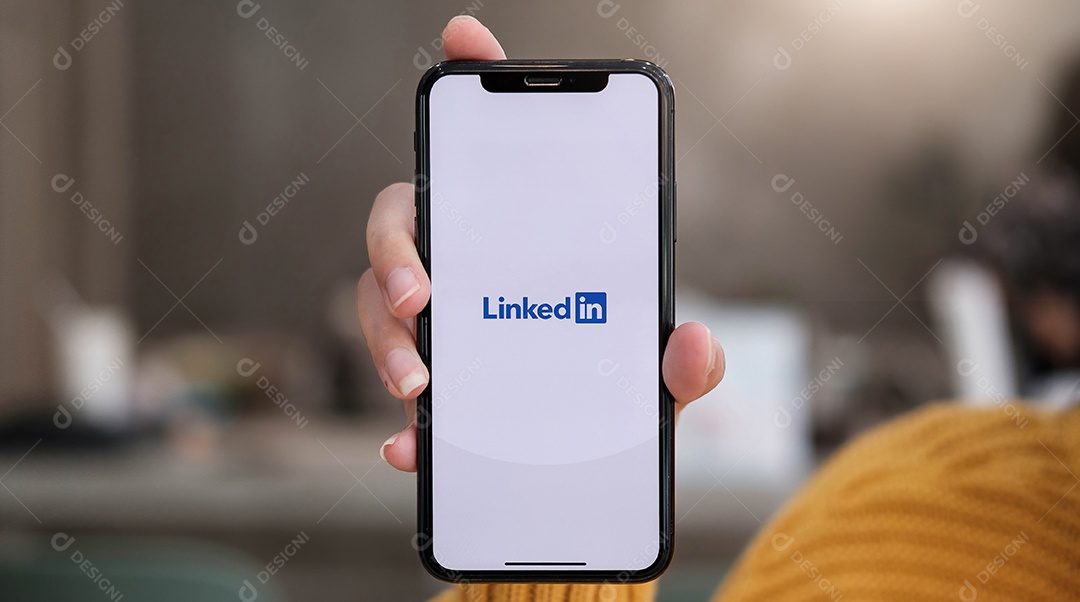 Uma mulher segura o Apple iPhone Xs com o aplicativo LinkedIn na tela.