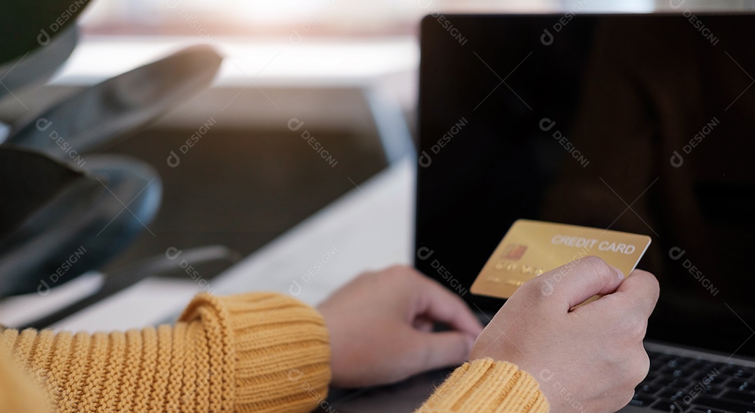 Pagamento on-line, as mãos do jovem usando o computador