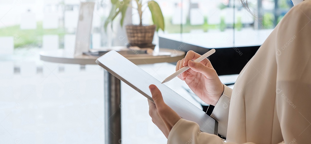 Mulher segurando um tablet digital com tela em branco e caneta stylus