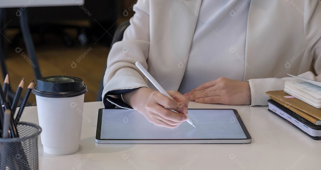 Mulher usando tablet digital com caneta stylus e teclado inteligente