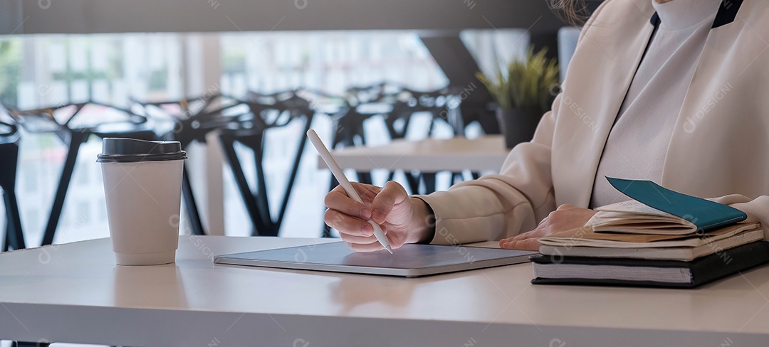Mulher usando tablet digital com caneta stylus e teclado inteligente
