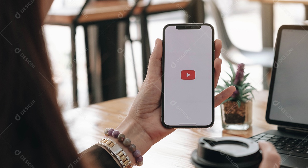 Mulher segurando um iPhone X ícone youtube