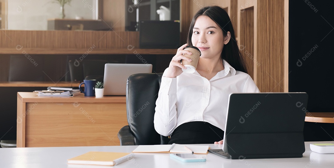 Retrato de uma jovem empresária usando a tela do laptop enquanto está sentada