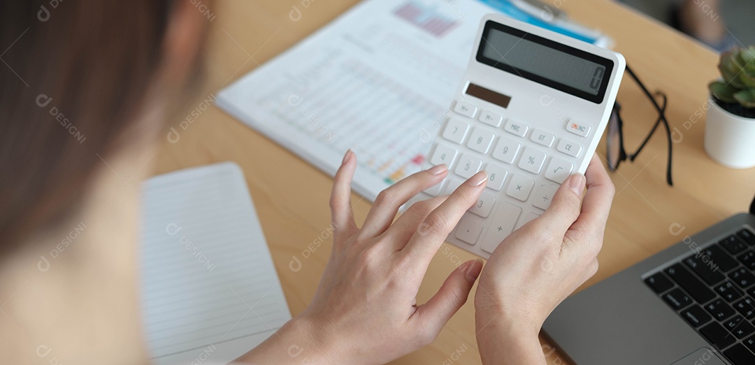 Mulher de negócios usando calculadora e laptop para fazer matemática