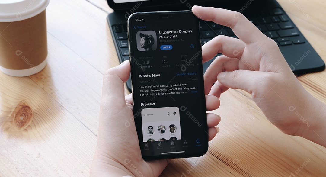 Mulher segurando Smartphone com ícone do Clubhouse
