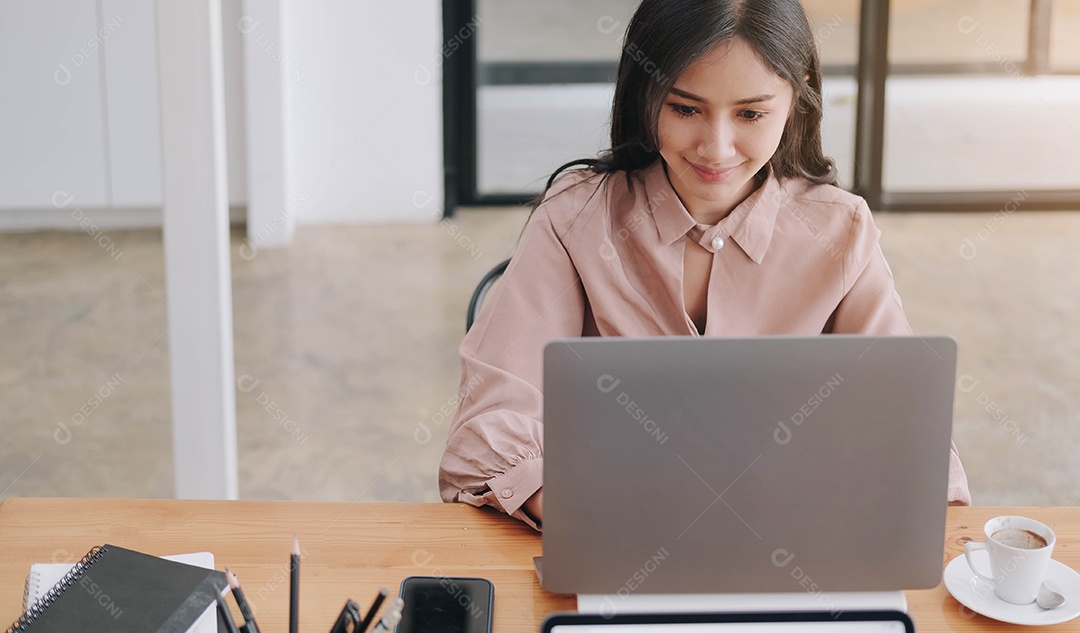 jovem ponderando ideias, sentada na mesa com o laptop