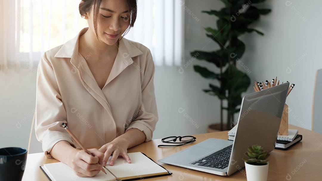 Aluno feliz aprendendo on-line e fazendo anotações em um bloco de notas