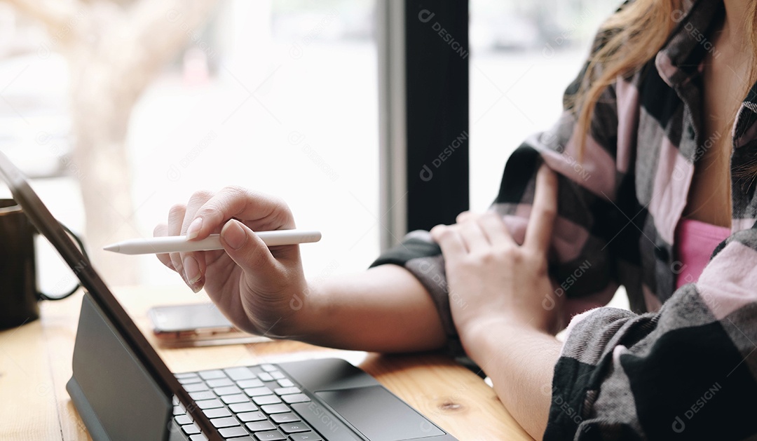 Mulher segurando a caneta stylus e aponte para a tela do tablet digital.