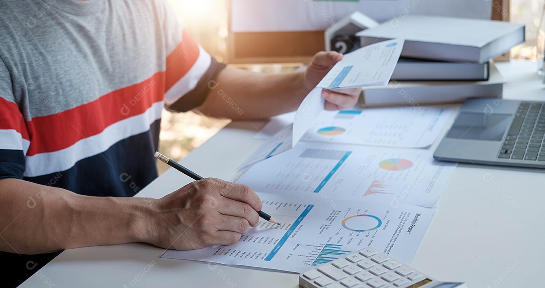 Um homem usando calculadora para calcular contas de despesas em seu trabalho