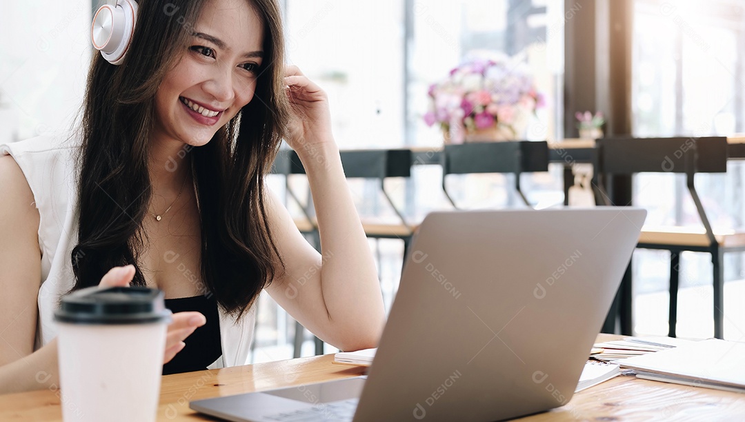Mulher asiática usando fones de ouvido estuda online