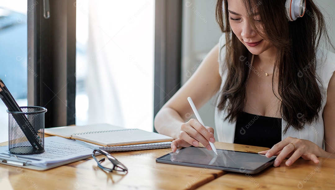 Foto de uma jovem empresária no local de trabalho usando seu tablet digital
