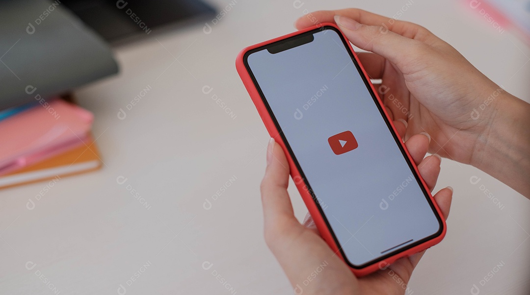 Mulher segurando um iPhone Xs ou iPhone 10 com serviço social de Internet Youtube na tela