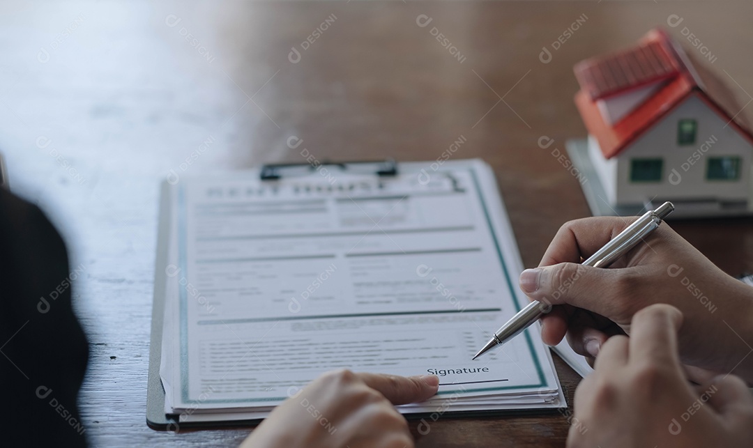 Um corretor de imóveis ou agente de seguros trabalha com modelos de casas