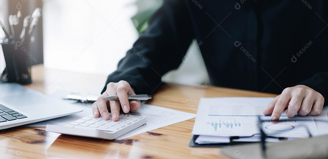 Mão da empresária ou do contador segurando a caneta trabalhando