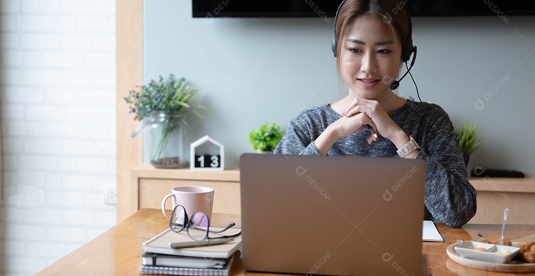 Sorridente mulher asiática freelancer usando fone de ouvido