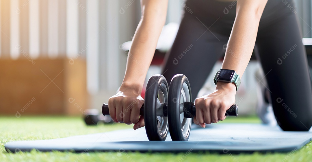 As mulheres fazem os exercícios com Ab Wheel na academia