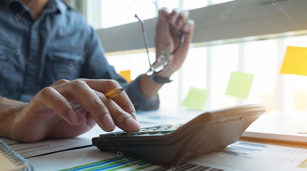 Empresário usando calculadora e laptop para calculações