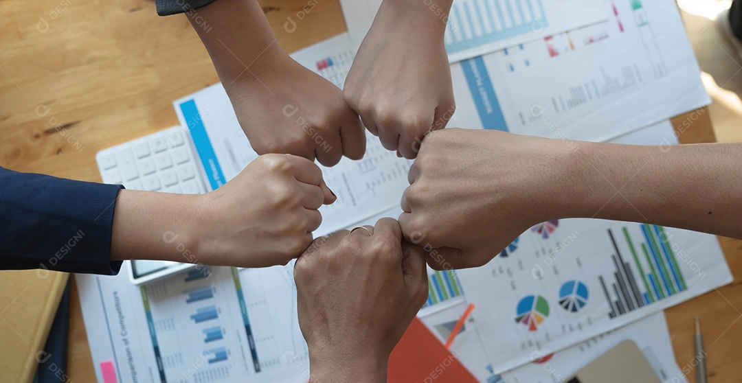 Vista superior de jovens empresários juntando as mãos.