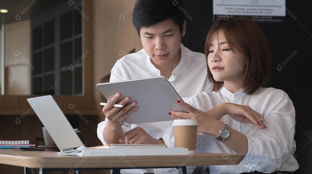 Jovens asiáticos trabalhando fazendo juntos no escritório