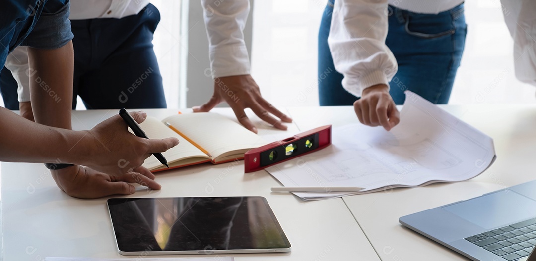 Arquiteto e engenheiro estão se reunindo para projeto trabalhando com parceiro com planta no local de trabalho