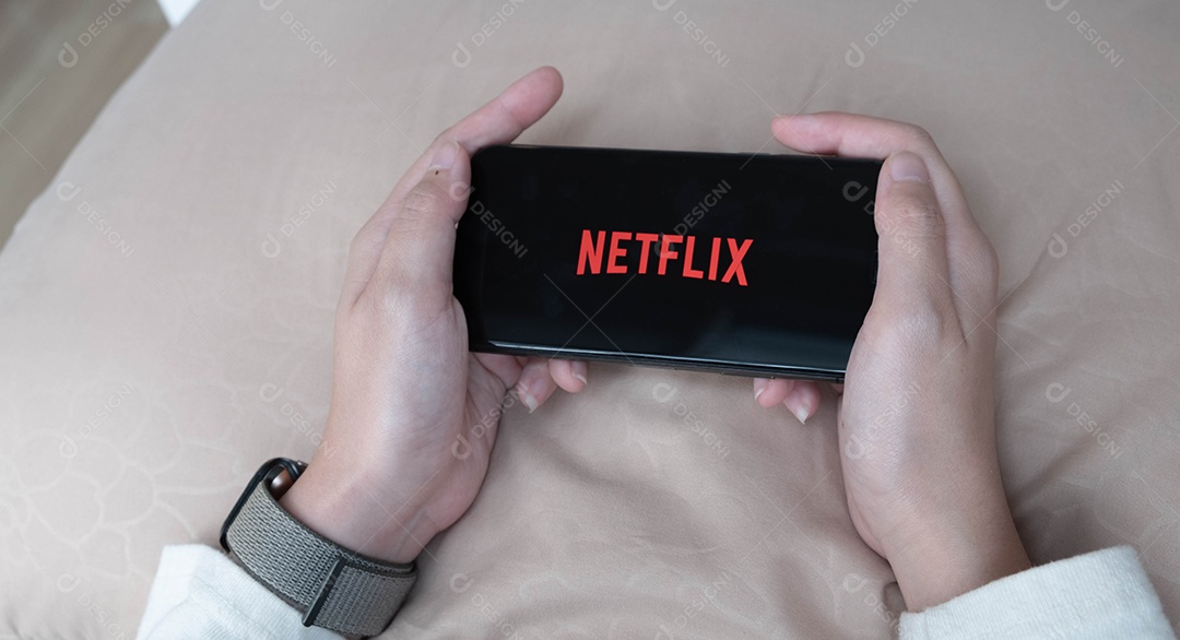 Mão de uma mulher segurando o Smartfone com logotipo da Netflix no Apple iPhone Xs.