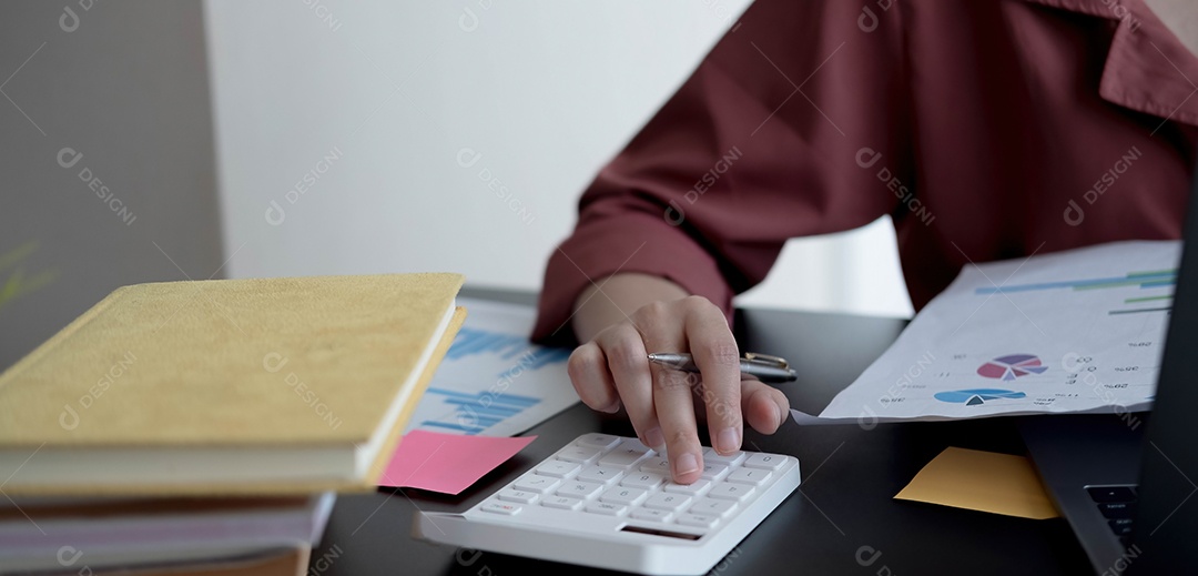 Mulher de negócios usando calculadora e laptop para fazer matemática