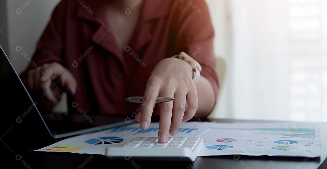 Mulher de negócios usando calculadora e laptop para fazer matemática