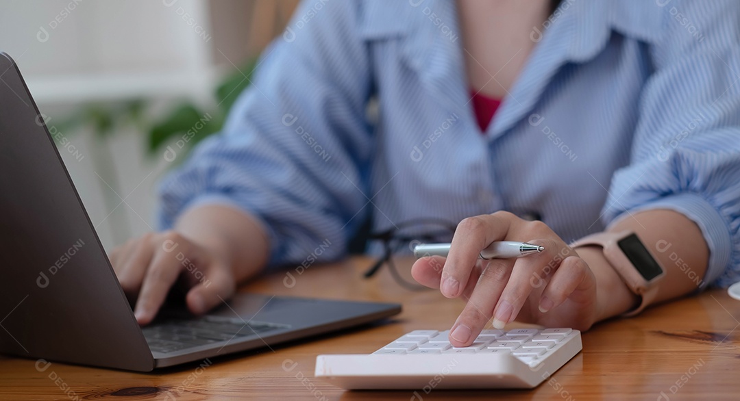 Mulher de negócios usando calculadora e laptop para fazer matemática