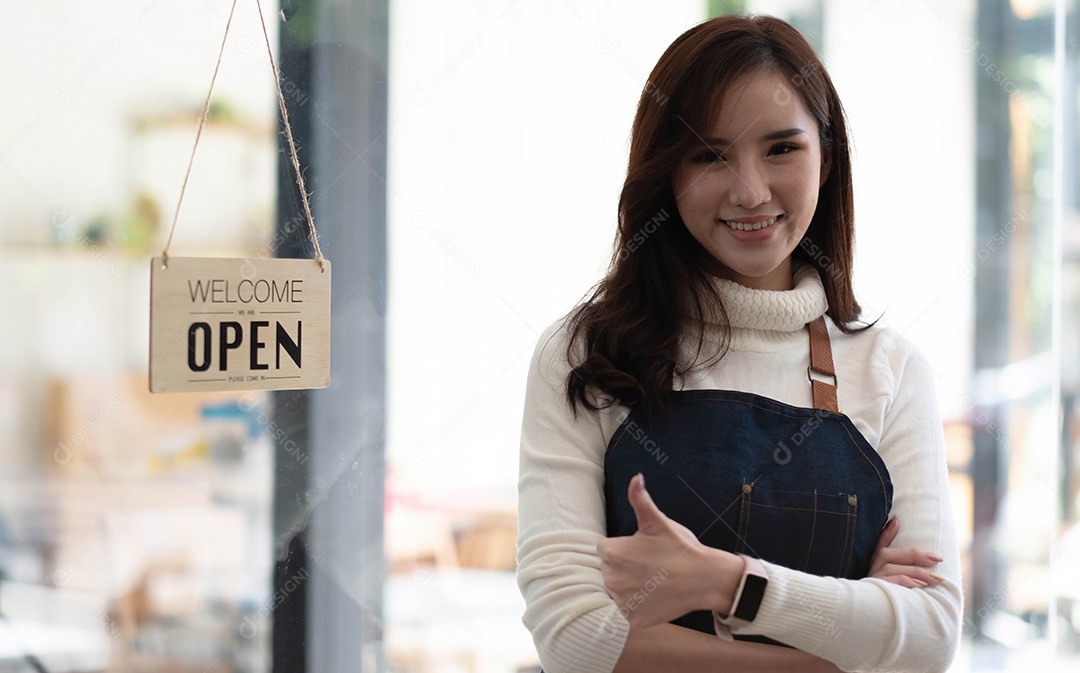 Proprietária de pequena empresa bem sucedido em pé com os braços cruzados