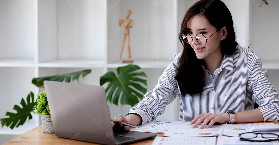 Mulher asiática do retrato que trabalha com computador portátil.