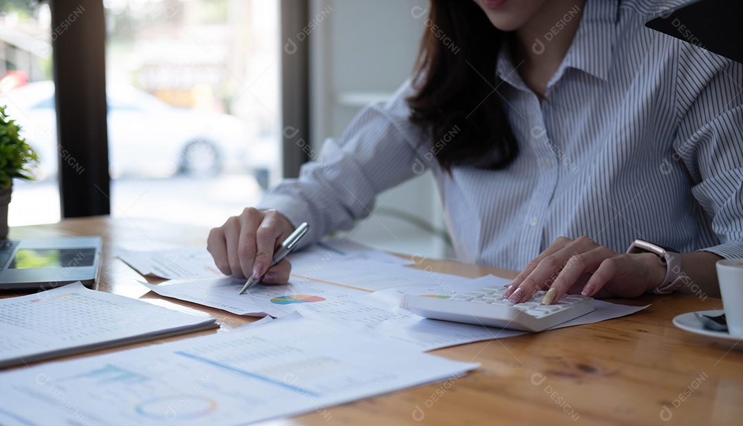 Mulher asiática com relatório financeiro e calculadora.