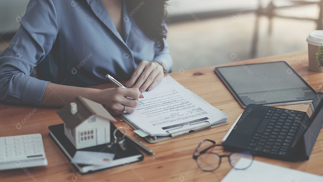 Agente imobiliário com mão modelo de casa colocando assinatura