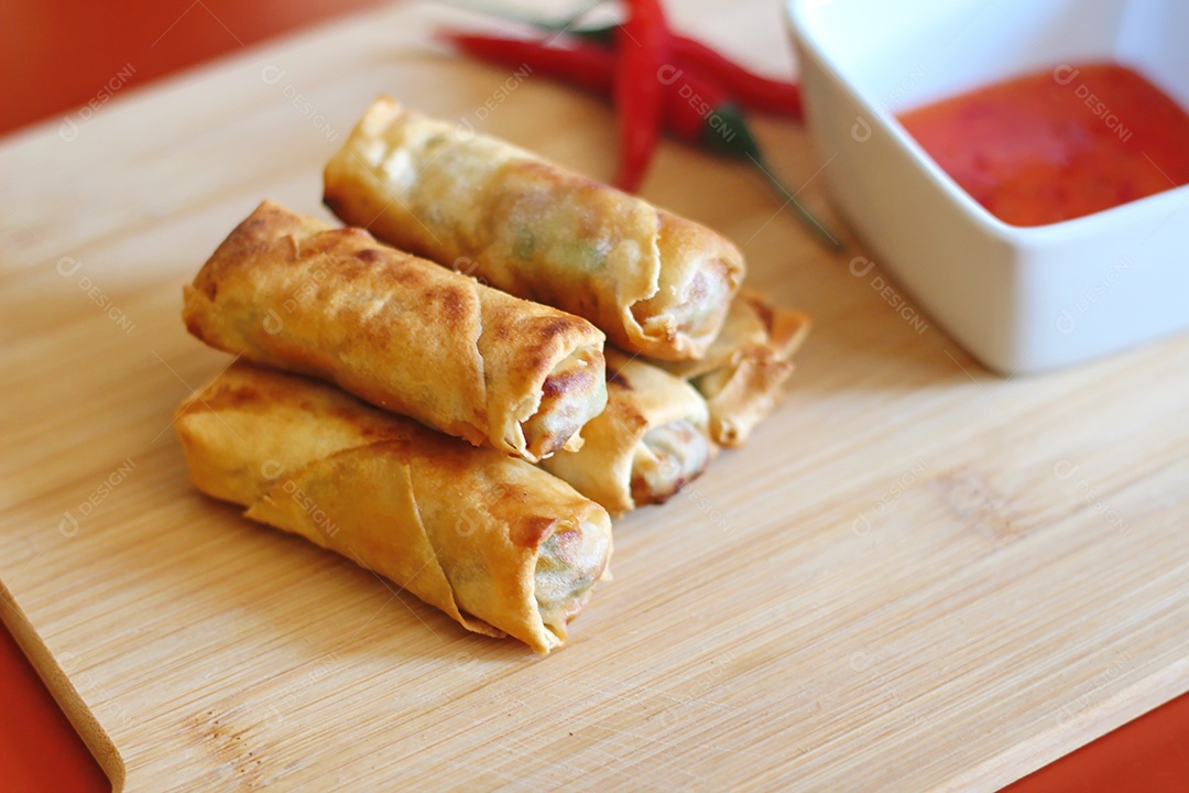 Rolinhos primavera com molho de pimenta no fundo de madeira