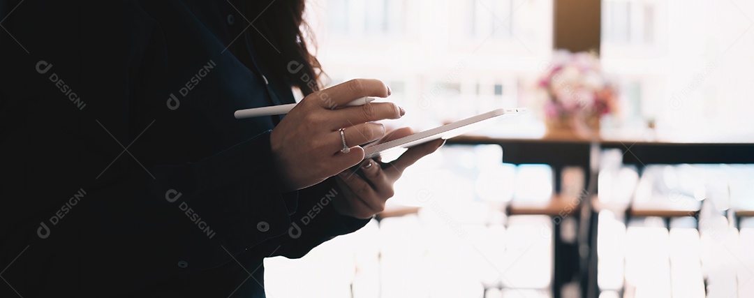 Mão de uma mulher usando tablet digital com tela sensível ao toque