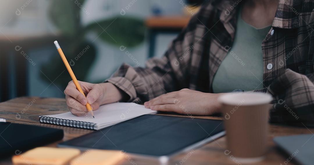 Aula online, aluno escrevendo no notebook enquanto estuda em casa