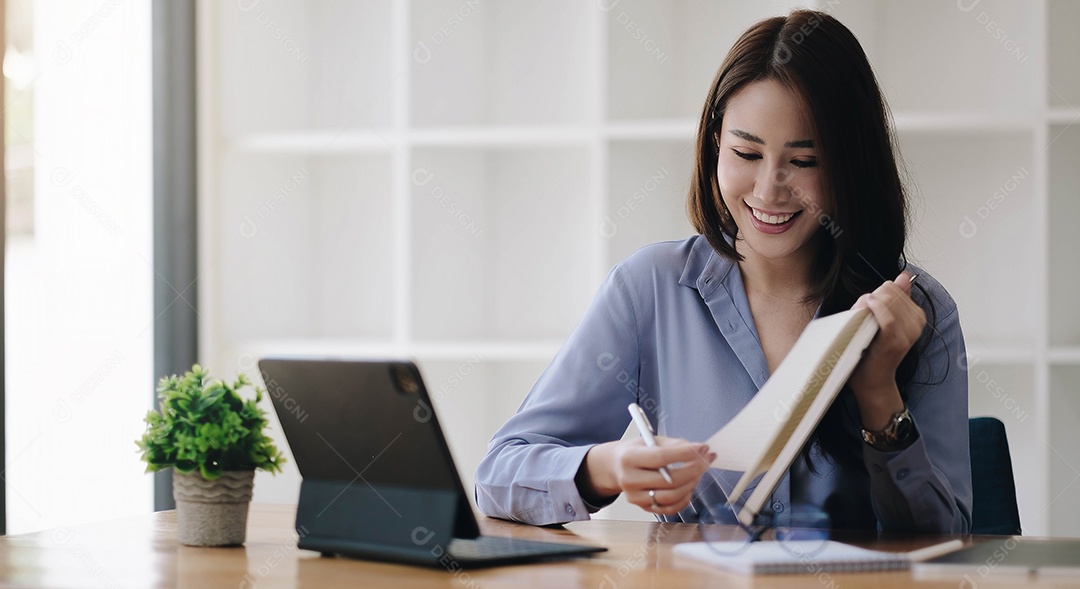 Mulher asiática de negócios tomando notas com vários itens colocados