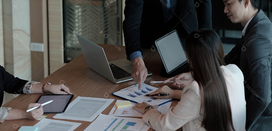 Colegas em reunião na sala de reuniões, sentados à mesa