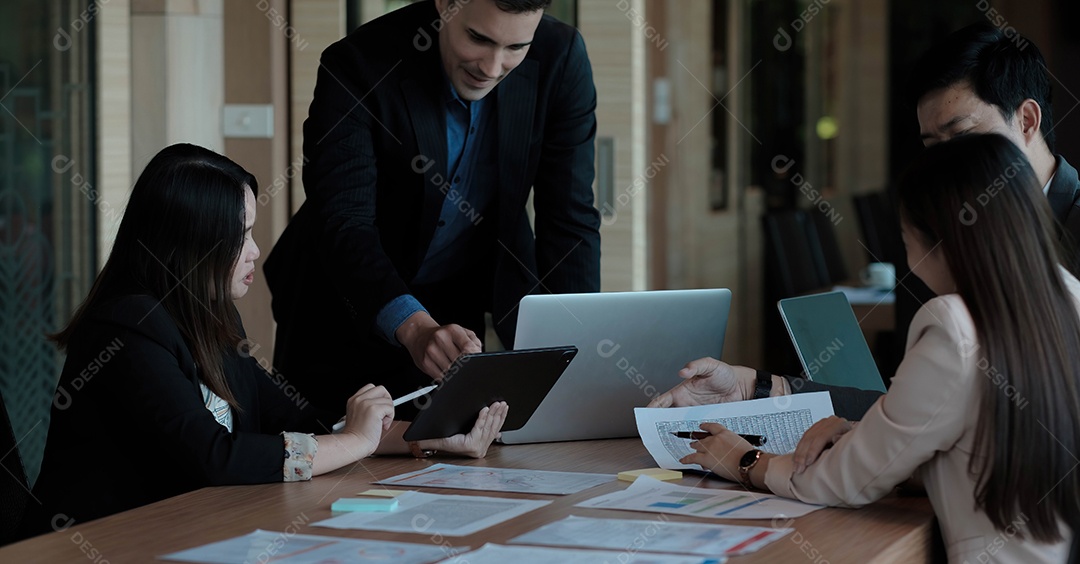 Vista frontal de diversos empresários trabalhando juntos no laptop