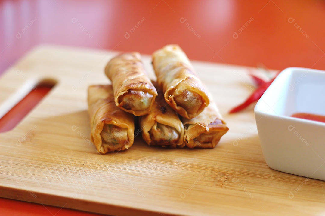 Rolinhos primavera com molho de pimenta no fundo de madeira