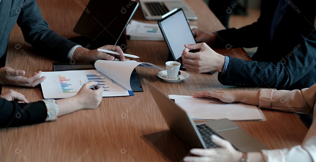 Colegas em reunião na sala de reuniões, sentados à mesa juntos
