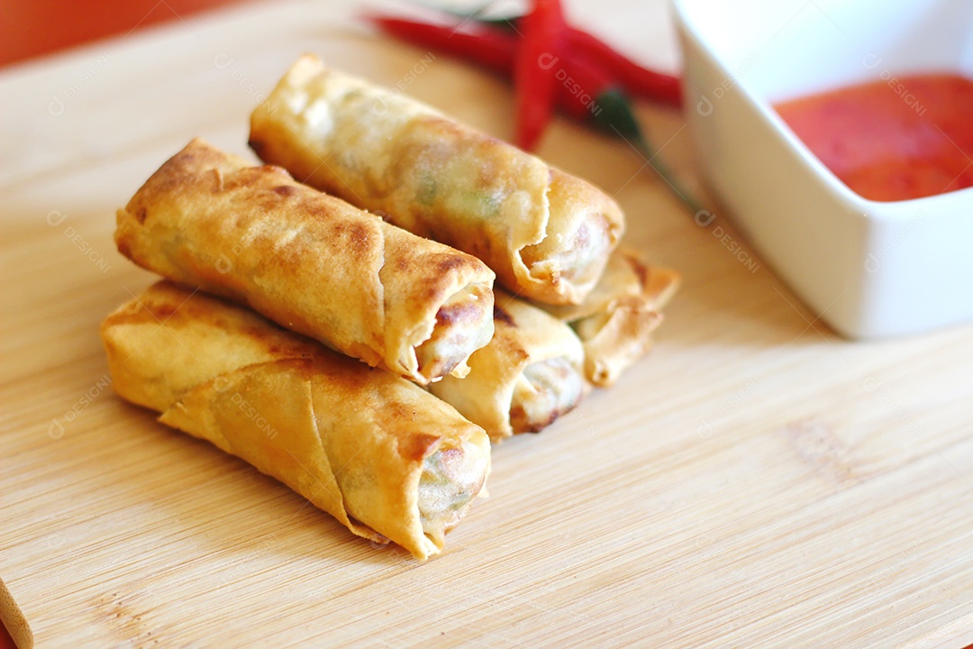 Rolinhos primavera com molho de pimenta no fundo de madeira