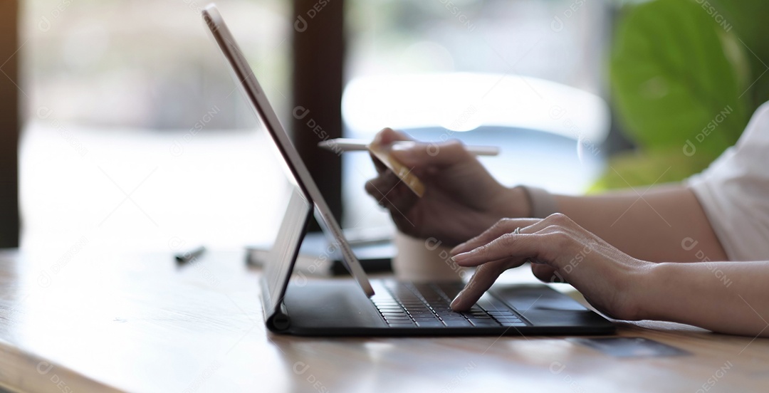 Mulher usando laptop com calculadora e cartão de crédito na mesa