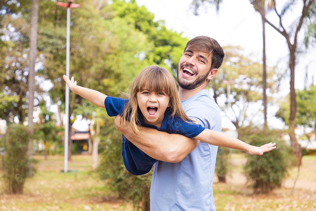 Pai e filha brincando no parque. Feliz Dia dos Pais Pai jogando em um avião com sua filha nos braços