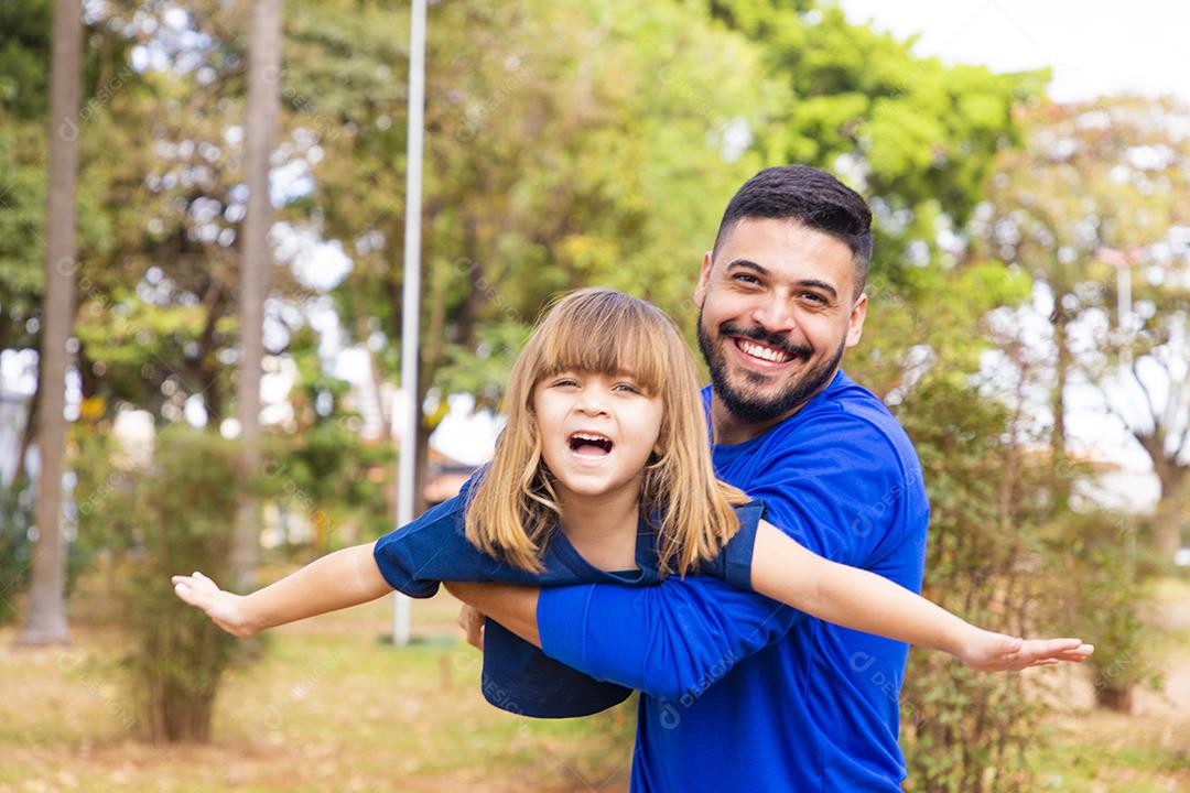 Pai e filha brincando no parque. Feliz Dia dos Pais Pai jogando em um avião com sua filha nos braços