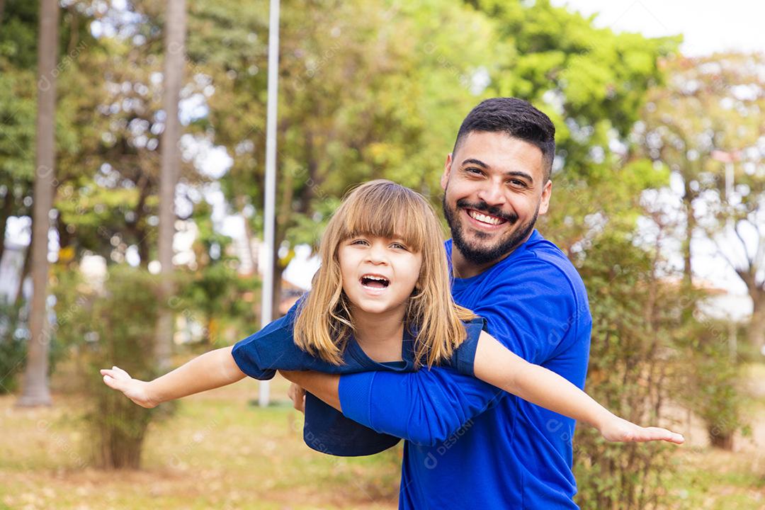 Pai e filha brincando no parque. Feliz Dia dos Pais Pai jogando em um avião com sua filha nos braços