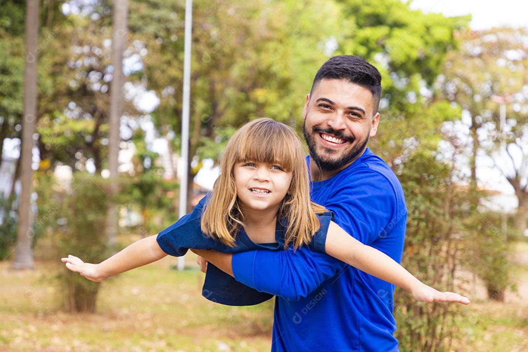 Pai e filha brincando no parque. Feliz Dia dos Pais Pai jogando em um avião com sua filha nos braços